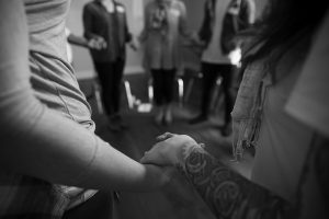 Support group holding hands in circle, in support