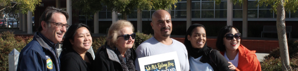 Advocates holding "we all belong here" sign