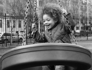 Child playing on a tire swing