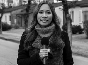 Portrait of news anchor holding microphone and smiling