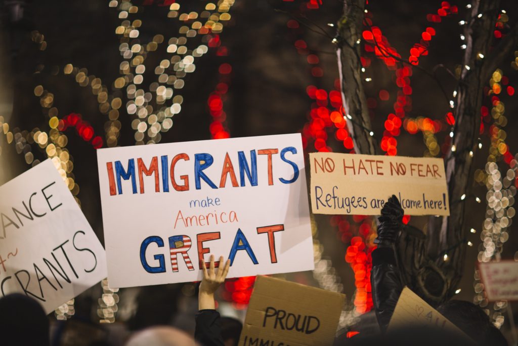 Signs that read "immigrants make America great" and "No hate, no fear, refugees are welcome here."