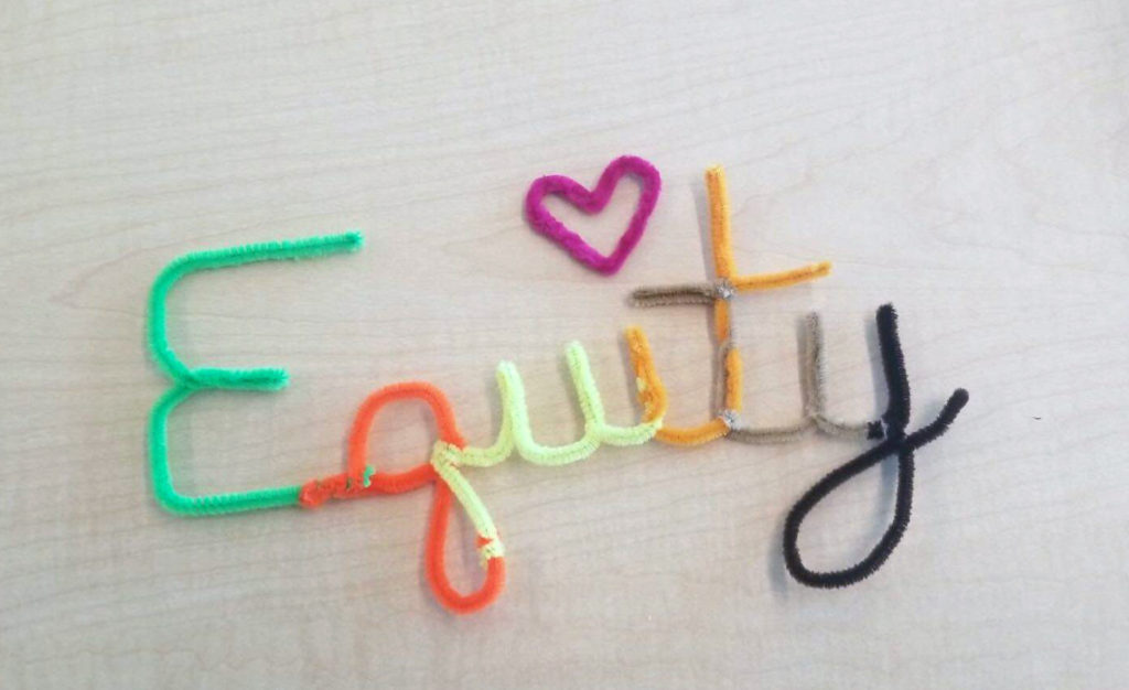 pipe cleaners arranged on a table to spell "equity"