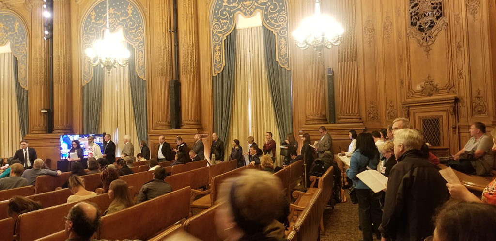 Speakers standing in a line at San Francisco City Hall.
