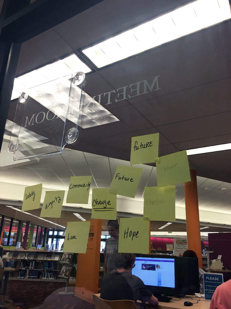 sticky notes on a window, showing values like "hope" and "dignity"