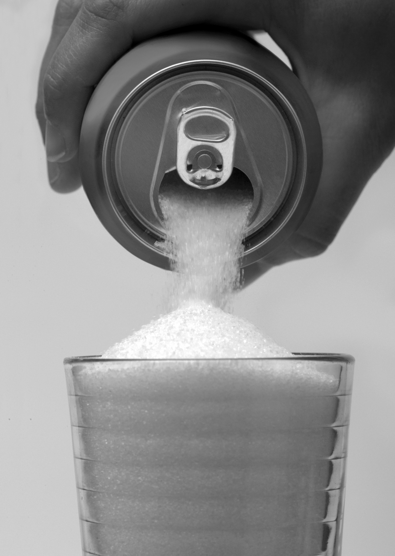 hand gripping soda can, pouring pure sugar into a glass